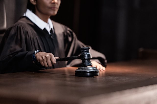 judge-in-robe-holding-a-gavel-at-a-courtroom-bench
