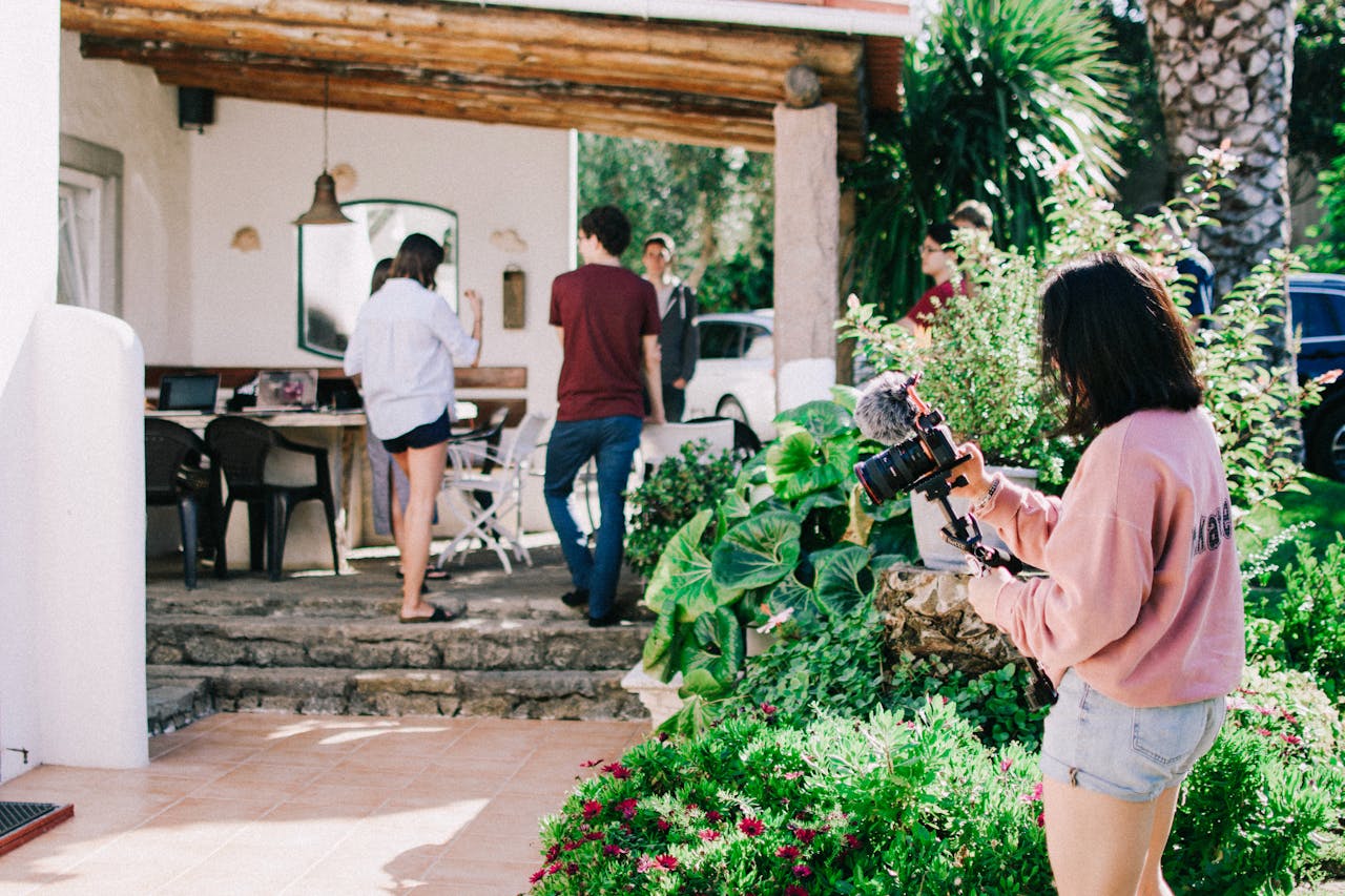 person with camera outside house